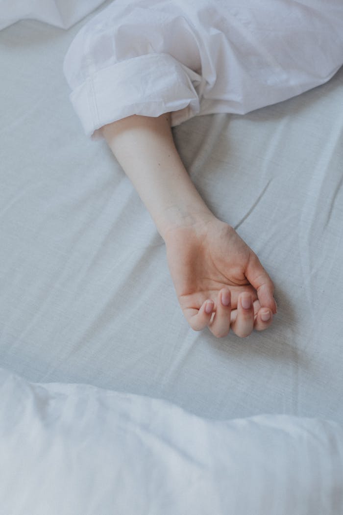 why-choose-us-02 Close-up of a relaxed arm resting on a white bed sheet, suggesting tranquility.
